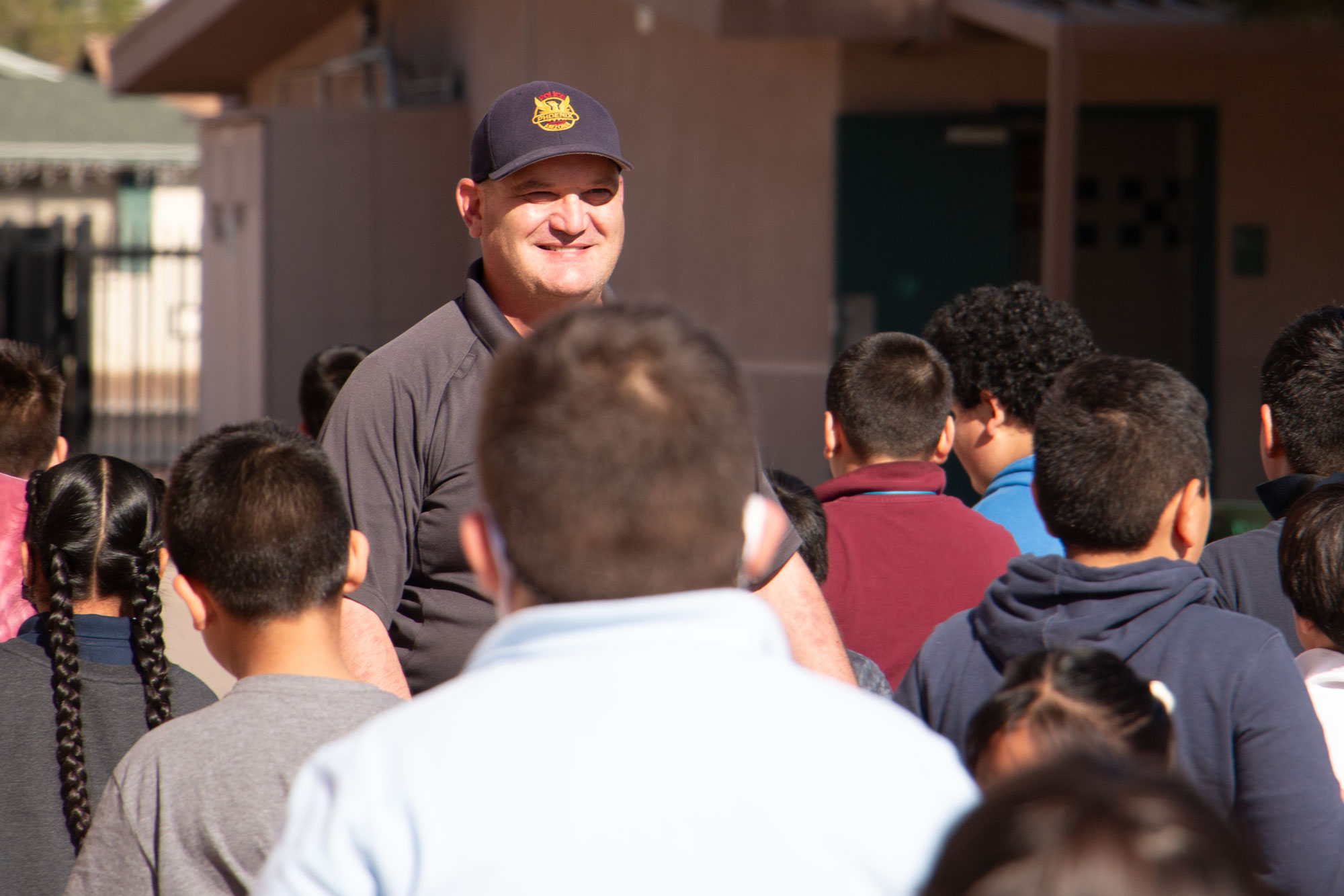 Brian Miller, a school resource officer for Charles W. Harris School in Phoenix, greets children at the school during his shift on Dec. 7, 2023. Positions like his are part of Arizona's School Safety Program. Photo by Brendon Derr | AZCIR