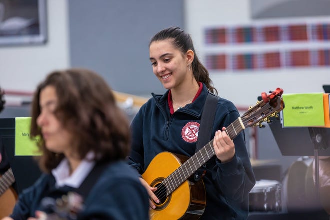 At Bishop Ireton High School in Alexandria, Virginia, a Catholic school where enrollment has grown since the pandemic, sophomore Mary Carlson practices during her guitar class.