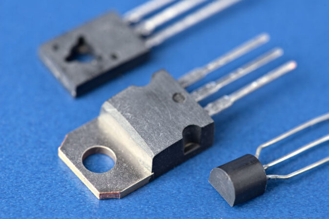 a photo of silver transistors against a blue background