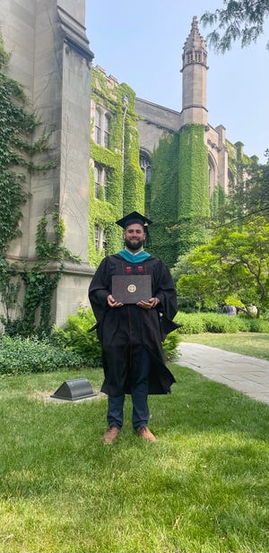 Amir Nijem displays his diploma after completing his public policy master's at the University of Chicago.