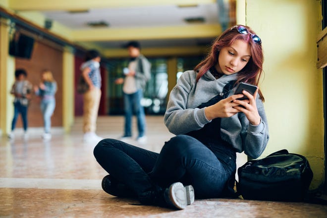 A student uses a smart phone at school.