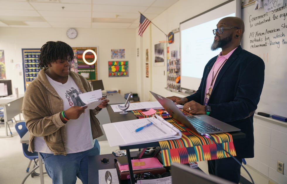 Caury Crusoe, left, speaks with her teacher, Sean Miller, during an AP African American Studies class at South County High School in Lorton, Virginia, on Feb. 15, 2024.
