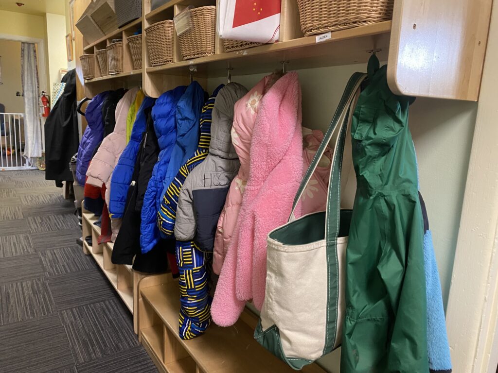 Children's coats hang in a hallway at Hillcrest Childcare Center in Anchorage o n April 18, 2024. (Photo by Claire Stremple/Alaska Beacon)