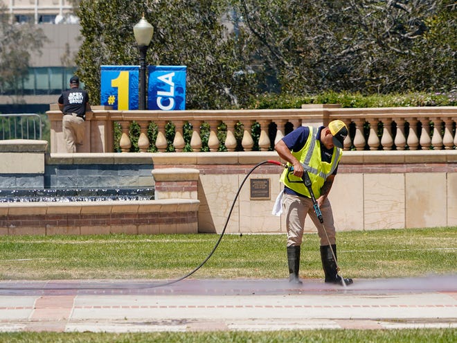 A worker cleans up Dickenson Plaza at the UCLA campus in the aftermath of student demonstrations in May.